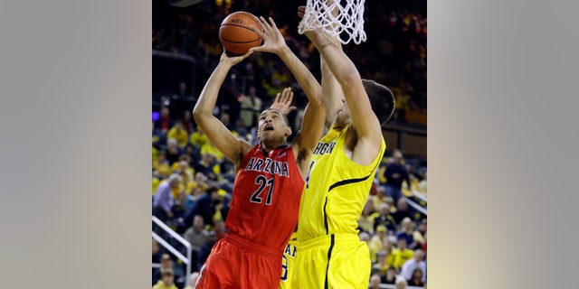 Arizona forward Brandon Ashley (21) makes a lay-up defended by Michigan forward Mitch McGary (4) during the second half of an NCAA college basketball game in Ann Arbor, Mich., Saturday, Dec. 14, 2013. (AP Photo/Carlos Osorio)