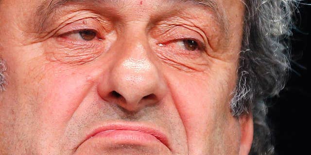 FILE - In this May 28, 2015 file photo President of UEFA Michel Platini grimaces during a press conference following a meeting of the UEFA board ahead of the FIFA congress in a hotel in Zurich, Switzerland. Complaining that he is being "dragged through the mud" in the FIFA corruption investigation, Michel Platini believes he is "bullet proof" and has not lost support in his bid to replace Sepp Blatter as the head of world soccer's governing body. The UEFA president, who has been suspended for 90 days along with Blatter, confirmed in an interview published Monday, Oct. 19, 2015 in the French daily Le Monde that he had no written contract for the $2 million payment he received from FIFA in 2011. (AP Photo/Michael Probst, File)