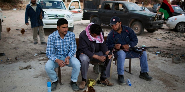 May 25: Rebel fighters clean their weapons near the east front line, 25 kilometers from Misrata, Libya.