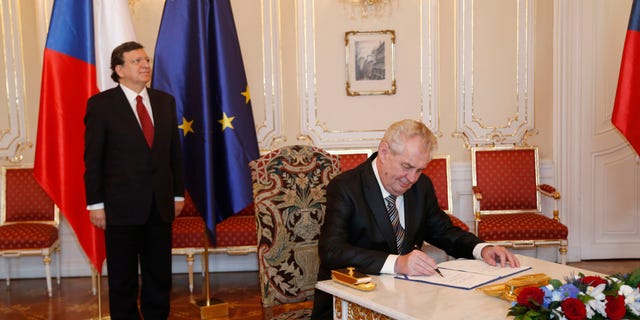 European Commission President Jose Manuel Barroso, left, looks on as Czech Republic's President Milos Zeman, right, signs the European Union bailout fund at the Prague Castle in Prague, Czech Republic, Wednesday, April 3, 2013. (AP Photo/Petr David Josek)