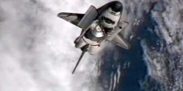 July 10: This frame grab from NASA-TV shows space shuttle Atlantis performing a pitch maneuver as it closes in for one last docking at the International Space Station.