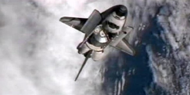 July 10: This frame grab from NASA-TV shows space shuttle Atlantis performing a pitch maneuver as it closes in for one last docking at the International Space Station.