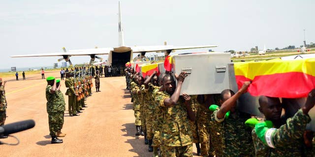 Ugandan soldiers carry the caskets of the Ugandan soldiers killed in Somalia, on arrival at Entebbe, Uganda, Thursday, Sept. 3, 2015. A Ugandan military spokesman says 12 Ugandan soldiers were killed in an attack Tuesday by Islamic extremists on an African Union base in Somalia. Lt. Col. Paddy Ankunda said Thursday that all soldiers were accounted for and that none was captured. He said 10 of the bodies will be flown back home Thursday. (AP Photo)