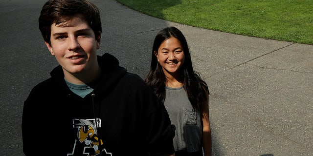 Alameda High School students Henry Mills, left, and Kristen Wong pose for photos on the school's campus.