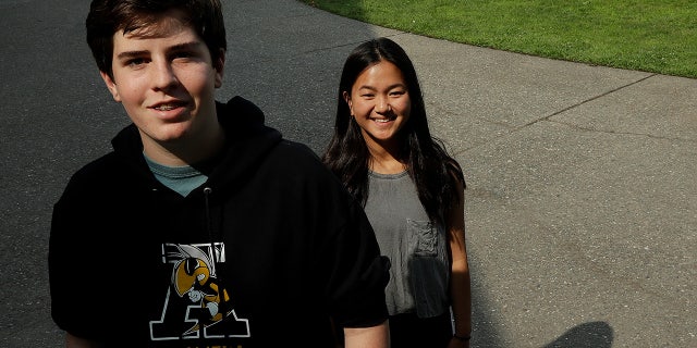Alameda High School students Henry Mills, left, and Kristen Wong pose for photos on the school's campus.