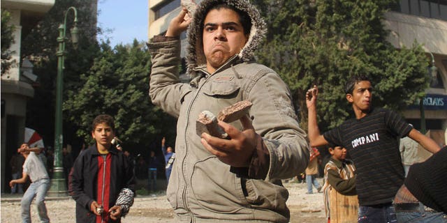 Dec. 16, 2011: Egyptian protesters throw rocks at military police during clashes near Cairo's downtown Tahrir Square, Egypt.