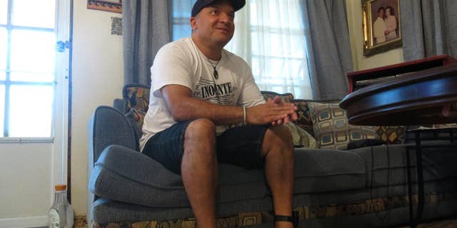 FILE - In this Aug. 6, 2016 file photo, Nelson Ortiz talks to a relative in Moca, Puerto Rico. Puerto Rico’s Justice Department has dropped charges on Tuesday, Sept. 27, 2016 against Ortiz and two other men who spent more than 20 years in prison for murder after new tests found none of their DNA on evidence in the case. They had been convicted in 1995 in the killing of 21-year-old pharmacy student Glorimar Perez. (AP Photo/Danica Coto, File)