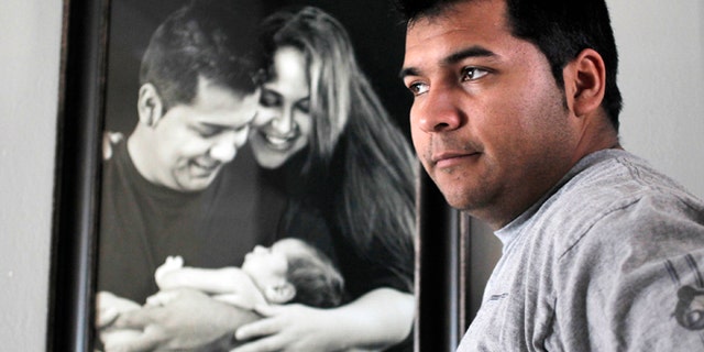 Erick Munoz and a photograph of himself with wife Marlise and their first son in Haltom City, Texas.