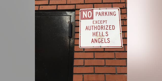 A sign near the front door of the Hells Angels motorcycle club headquarters in New York reads "No Parking Except Authorized Hells Angels," Friday, Dec. 16, 2016. The latest clash between New York City Police and the Hells Angels came after a man from upstate New York tried to move an orange cone meant to hold a sparking spot for club members and ended up hospitalized with a gunshot wound. (AP Photo/Tom Hays)