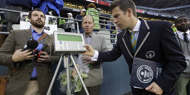 September 15, 2013: Philip Robertson, right, an adjudicator with Guinness World Records, examines a device used to measure the sound level of cheering fans at CenturyLink Field in Seattle prior to an NFL football game between the Seattle Seahawks and the San Francisco 49ers. (AP Photo)