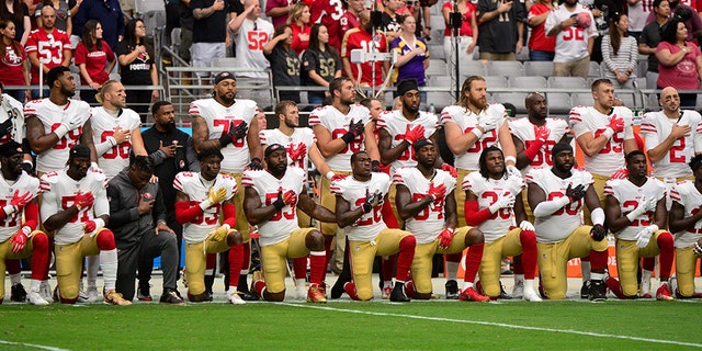Members of the San Francisco 49ers kneeling during the National Anthem Sunday before their game against the Arizona Cardinals.