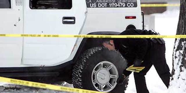 Jan. 1, 2007: An investigator with the Denver Police Department places evidence markers next to the Hummer limo in which Darrent Williams was killed.