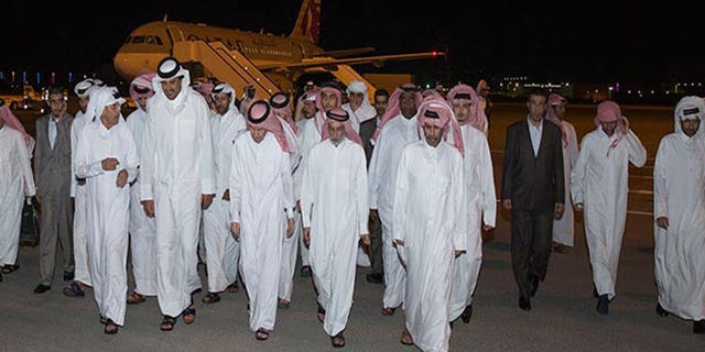In this photo released by Qatar News Agency, Emir of Qatar Sheikh Tamim bin Hamad Al Thani, second left in front row, receives the released Qataris at the Doha airport in Doha, Qatar Friday, April 21, 2017.