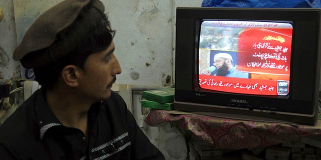 A Pakistani watches a local news channel broadcasting a report about a passenger plane taking off from Chitral, in the country's north, that crashed near a village near the town of Havelian, at his shop in Lahore, Pakistan, Wednesday, Dec. 7, 2016. The plane belonging to Pakistan's national carrier crashed on Wednesday with about 42 passengers and five crew members and an engineer on board, apparently killing all of them, police and an airline spokesman said. (AP Photo/K.M. Chaudary)