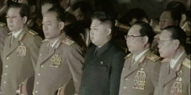 Dec. 24, 2011: Kim Jong Un, center, North Korean leader Kim Jong Il's youngest known son and successor, with military officials, stand in front of his father's body displayed in a glass coffin, not in photo, at Kumsusan Memorial Palace in Pyongyang, North Korea.