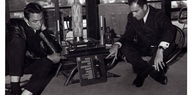 Johnny Cash and Saul Holiff in Saul’s Hollywood apartment, 1962. They are pointing at Johnny’s album, "The Sound of Johnny Cash".