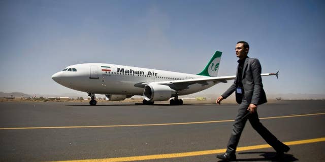 FILE -- A Yemeni airport security official walks on the tarmac next to a plane from the Iranian private airline Mahan Air at the international airport in Sanaa, Yemen, Sunday, March 1, 2015.