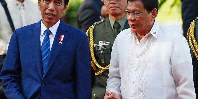 Indonesian President Joko "Jokowi" Widodo, left, chats with Philippine President Rodrigo Duterte following a welcoming ceremony at the Malacanang Palace grounds in Manila, Philippines, Friday, April 28, 2017. Widodo is attending the 30th ASEAN Leaders' Summit which the Philippines is hosting. (AP Photo/Bullit Marquez)