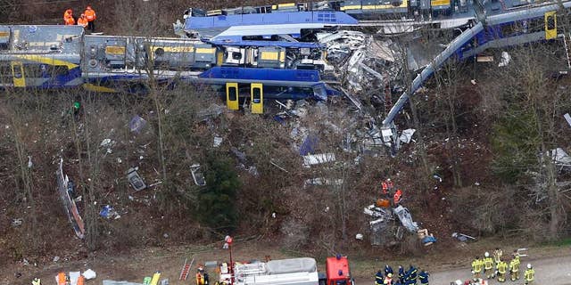 FILE - In this Feb. 9, 2016 file photo rescue teams work at the site where two trains collided head-on near Bad Aibling, Germany, killing twelve people and injuring 89. On Monday, Dec. 5, 2016 the train dispatcher was sentenced to 3 years and six months in prison because of negligence that led to one of the worst train crashes in German history this year. (AP Photo/Matthias Schrader, file)
