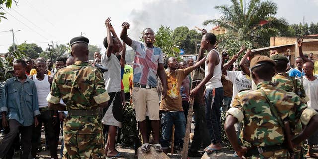 FILE - In this May 27, 2015 file photo, opposition demonstrators confront army soldiers in the Mutarakura district, as security forces try to prevent people moving out of their neighborhoods, in the capital Bujumbura, Burundi. A global human rights umbrella organization issued a report on Tuesday, Nov. 15, 2016, urging Africa, Europe and the United Nations to send a civilian protection force to Burundi to prevent a possible civil war and genocide. (AP Photo/Gildas Ngingo, File)