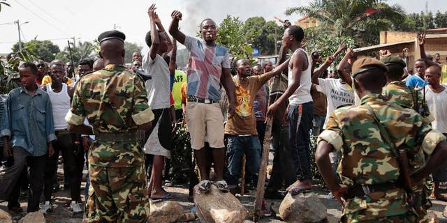 FILE - In this May 27, 2015 file photo, opposition demonstrators confront army soldiers in the Mutarakura district, as security forces try to prevent people moving out of their neighborhoods, in the capital Bujumbura, Burundi. A global human rights umbrella organization issued a report on Tuesday, Nov. 15, 2016, urging Africa, Europe and the United Nations to send a civilian protection force to Burundi to prevent a possible civil war and genocide. (AP Photo/Gildas Ngingo, File)
