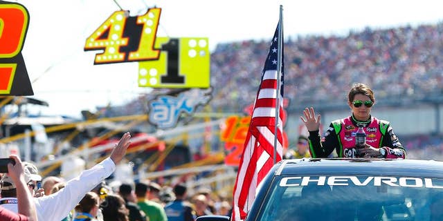 Danica Patrick, right, waves to fans as she rides in a truck to her car for the NASCAR Sprint Cup Series auto race at Talladega Superspeedway, Sunday, Oct. 19, 2014, in Talladega, Ala. (AP Photo/John Bazemore)
