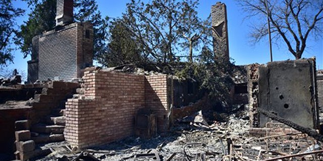 Fire damage to a home Thursday, March 24, 2016 near Medicine Lodge, Kan. A fire that started Tuesday in Oklahoma has now burnt near 400, 000 acres in Kansas and Oklahoma. (Andrew Whitaker/ The Hutchinson News via AP)