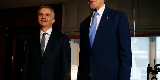 U.S. Secretary of State John Kerry, right, poses with Swiss President Didier Burkhalter for photographers in Davos, Switzerland, Friday, Jan. 24, 2014. Kerry is attending the annual World Economic Forum meeting in the Swiss Alps. (AP Photo/Gary Cameron, Pool)