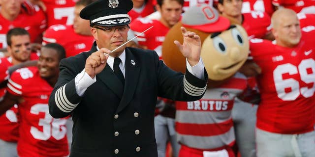 FILE - In this Sept. 7, 2013 file photo, Ohio State University marching band director Jonathan Waters leads the band in "Carmen Ohio" following a NCAA football game against San Diego State at Ohio Stadium in Columbus, Ohio. Ohio State officials say there is no recent record of campus police attending an annual ritual where marching band members entered Ohio Stadium in their underwear. The Midnight Ramps were cited in an investigation into the band's "sexualized culture" that resulted in Waters’ July 24 firing. (AP Photo/The Columbus Dispatch, Adam Cairns, File)