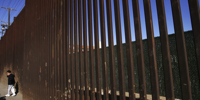MEXICALI, BAJA CALIFORNIA - MARCH 25: A boy walks along the US/Mexico border fence on March 25, 2005 in Mexicali, Baja California, Mexico. Since the launch of the North American Free Trade Agreement in 1995, two-way trade has boomed between the US and Mexico, and Mexican dollars are fueling development in economically-depressed Calexico, California. Border communities are now growing increasingly worried that the recent economic gains may be lost as the Bush administration's efforts to tighten security in order to prevent terrorists or their weapons from crossing the border could slow the wheels of commerce. (Photo by David McNew/Getty Images)