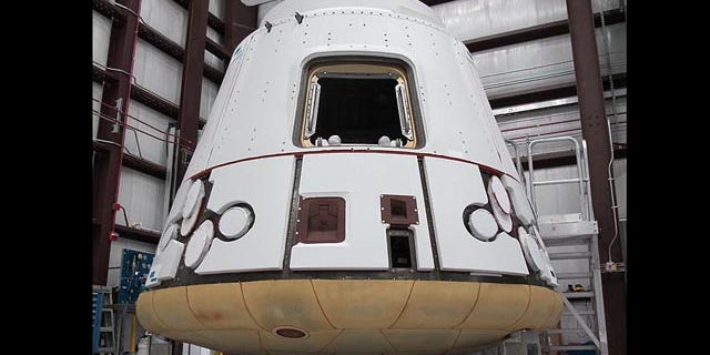 In the SpaceX hangar at Cape Canaveral, the Dragon spacecraft prepares for integration with the Falcon 9 launch vehicle. Visible at the base of the spacecraft is Dragon�s heat shield, made of PICA-X, the SpaceX manufactured variation on NASA�s Phenolic Impregnated Carbon Ablator (PICA) heat shield material. Dragon will reenter the Earth�s atmosphere at around 7 kilometers per second (15,660 miles per hour), heating the exterior up to 1850 degrees Celsius. However, just a few inches of the PICA-X material will keep the interior of the spacecraft at a comfortable temperature.
