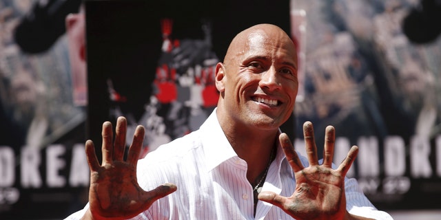 actor dwayne "the rock is" Johnson poses with his hands in cement during the Hand and Footprint ceremony in the forecourt of the TCL Chinese Theater in celebration of his film. "San Andreas," May 19, 2015 in Hollywood, California.