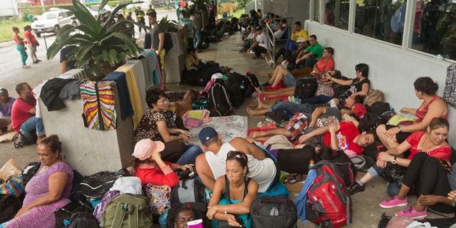 Cuban migrants sit outside a Costa Rican immigration building on the border with Nicaragua, in Peñas Blancas, Costa Rica, after Nicaragua closed its border to all Cuban migrants, leaving them stuck in Costa Rica. (AP Photo/Esteban Felix, File)