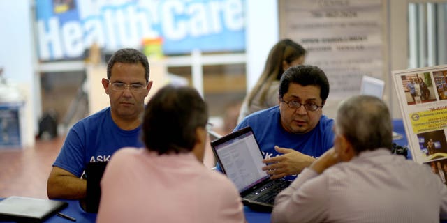 Insurance agents help people with the Affordable Care Act on November 5, 2013 in Miami, Florida.