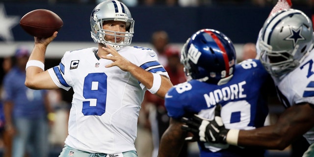 Dallas Cowboys' Tony Romo (9) prepares to pass as Jermey Parnell, right, defends against a rush by New York Giants defensive end Damontre Moore, center, during the first half of an NFL football game, Sunday, Oct. 19, 2014, in Arlington, Texas. (AP Photo/Brandon Wade)