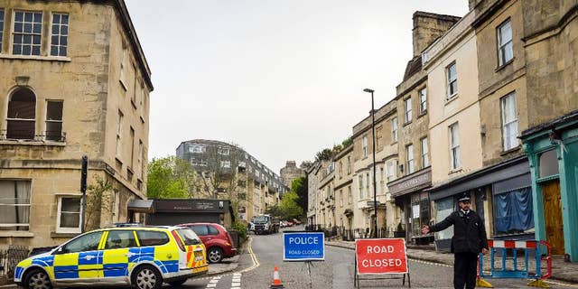 Police divert away traffic from an exclusion zone set up after contractors unearthed a Second World War shell in Bath, England, Friday, May 13, 2016. Hundreds of people have been told to leave homes and businesses in the English city of Bath after a 500-pound (225-kilogram) unexploded World War II shell was found under a school playground. Police evacuated residents for 300 meters (yards) around the device, found during construction work at the disused Royal High School. Some spent the night at a local racecourse. (Ben Birchall/PA via AP)      UNITED KINGDOM OUT        -     NO SALES       -       NO ARCHIVES