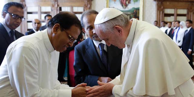 Pope Francis shakes hands with President Maithripala Sirisena at the end of a private audience at the Vatican, Monday, Dec. 14, 2015. (AP Photo/Gregorio Borgia, Pool)