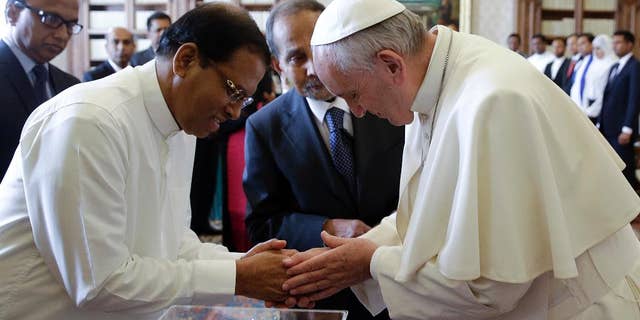 Pope Francis shakes hands with President Maithripala Sirisena at the end of a private audience at the Vatican, Monday, Dec. 14, 2015. (AP Photo/Gregorio Borgia, Pool)