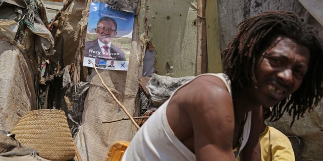 A supporter of Presidential candidate Hery Rajaonarimampianina, displays his poster, outside his home in the city of Antananarivo, Madagascar, Thursday, Oct. 24, 2013. Madagascar will hold elections on Friday that organizers hope will end political tensions that erupted in a 2009 coup and help lift the aid-dependent country out of poverty. The island nation in the Indian Ocean plunged into turmoil after Andry Rajoelina, the current president, forcibly took power from former President Marc Ravalomanana with the backing of the military. (AP Photo/Schalk van Zuydam)