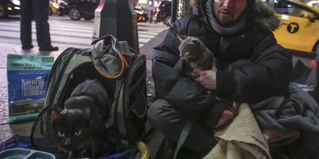 Keith Rosario sits with his cats outside Pennsylvania Station in New York City.