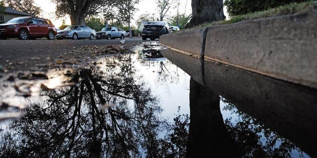 This Sunday, April 13, 2015 photo shows water from a leaking pipe flowing along the curbside of a street in Los Angeles. Southern California's water wholesaler is considering a proposal that would reduce the amount of water it delivers to more than two dozen cities and agencies in the wake of an ongoing drought. A board committee of the Metropolitan Water District meets Monday, April 13, to mull a plan to cut water deliveries by 15 percent beginning this summer. (AP Photo/Richard Vogel)