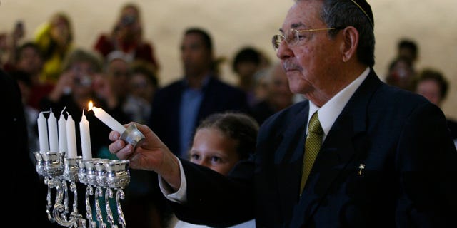 Cuba's President Raul Castro lights a Hanukkah candle during a ceremony at the Bet Shalom synagogue in Havana, Cuba, Sunday Dec. 5, 2010. (AP Photo/Ismael Francisco, Prensa Latina)