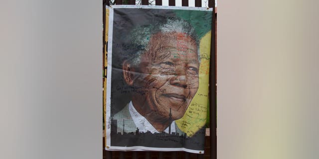A giant signed poster with messages of support is attached to the former Soweto home, turned museum, of former South African president Nelson Mandela, Soweto, South Africa, Friday Dec. 6 2013. Mandela passed away Thursday night after a long illness. He was 95. As word of Mandela's death spread, current and former presidents, athletes and entertainers, and people around the world spoke about the life and legacy of the former South African leader. (AP Photo/Athol Moralee)
