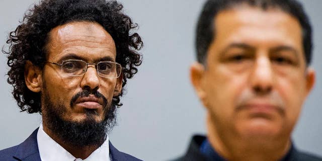 Ahmad Al Mahdi Al Faqi, left, enters the court room for his initial appearance at the International Criminal Court in The Hague, Netherlands, Wednesday, Sept. 30, 2015. Al Faqi, an alleged Islamic radical, is the first suspect in the court's custody charged with the war crime of deliberately attacking and destroying religious or historical monuments in Timbuktu, Mali. (AP Photo/Robin van Lonkhuijsen, Pool)
