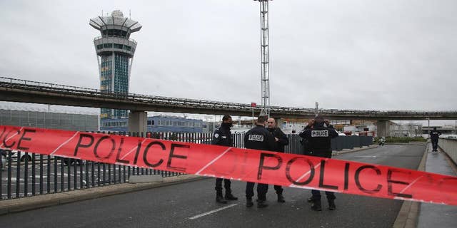 Police officers cordon off the access to the Orly airport, south of Paris, Saturday, March, 18, 2017. A man was shot to death Saturday after trying to seize the weapon of a soldier guarding Paris' Orly Airport, prompting a partial evacuation of the terminal, police said. Authorities warned visitors to avoid the area while an ongoing police operation was underway. (AP Photo/Thibault Camus)