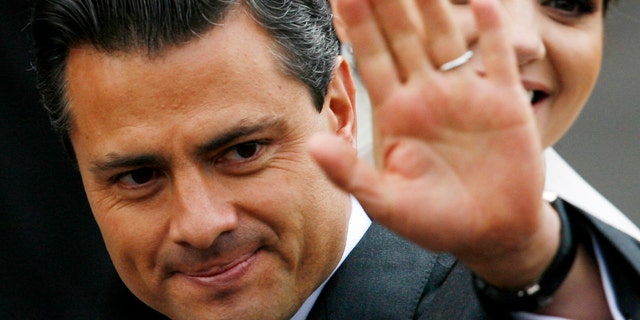 FILE - In this Nov. 27, 2010 file photo, Enrique Pena Nieto, governor of the state of Mexico, waves prior to his wedding with Mexican actress Angelica Rivera, behind, at the Metropolitan Cathedral in Toluca, Mexico. Pena Nieto, the former governor of Mexico State, told the Televisa network late Monday Sept. 19, 2011 that he plans to seek the nomination to run in the July 2012 presidential election for the Institutional Revolutionary Party, or PRI.  Pena Nieto, 45, is seen as the PRI's best chance to regain the presidency it held for more than 70 years before losing to Vicente Fox in 2000 and then Felipe Calderon in 2006, both of the rival National Action Party, or PAN.  (AP Photo/Marco Ugarte, File)
