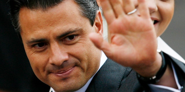 FILE - In this Nov. 27, 2010 file photo, Enrique Pena Nieto, governor of the state of Mexico, waves prior to his wedding with Mexican actress Angelica Rivera, behind, at the Metropolitan Cathedral in Toluca, Mexico. Pena Nieto, the former governor of Mexico State, told the Televisa network late Monday Sept. 19, 2011 that he plans to seek the nomination to run in the July 2012 presidential election for the Institutional Revolutionary Party, or PRI. Pena Nieto, 45, is seen as the PRI's best chance to regain the presidency it held for more than 70 years before losing to Vicente Fox in 2000 and then Felipe Calderon in 2006, both of the rival National Action Party, or PAN. (AP Photo/Marco Ugarte, File)