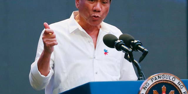 FILE - In this Thursday, Oct. 13, 2016, file photo, Philippine President Rodrigo Duterte gestures during his address to a Filipino business sector in suburban Pasay city, south of Manila, Philippines. Duterte acknowledged Sunday, Oct. 16, 2016, that he can be impeached if he concedes the country's territorial claims in the South China Sea in upcoming talks with Chinese President Xi Jinping and other Chinese leaders in Beijing. (AP Photo/Bullit Marquez, File)