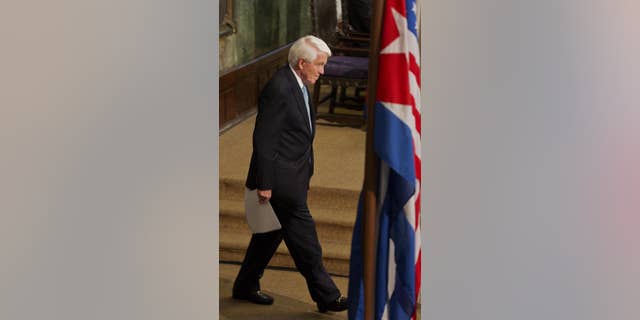 U.S. Chamber of Commerce President and CEO Thomas Donohue walks in front of the Cuban and US flags before a conference at the auditorium of the University in Havana, Cuba, Thursday, May 29, 2014. Donahue urged Cuba to deepen economic reforms on the island, and the US to take steps to normalize relations with the Caribbean nation. (AP Photo/Ramon Espinosa)