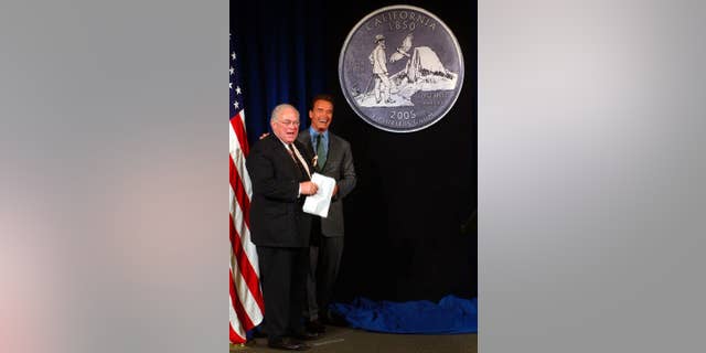 FILE - In this March 29, 2004, file photo, California Gov. Arnold Schwarzenegger, right, and state Librarian Kevin Starr, smile after unveiling the design chosen for the California Quarter during ceremonies in Sacramento, Calif. Starr, California's former librarian and one of the state's premier historians, died Saturday, Jan. 14, 2017. He was 76 (AP Photo/Rich Pedroncelli, File)